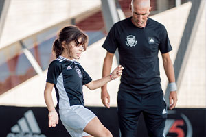 Zidane qui joue au foot avec une jeune fille